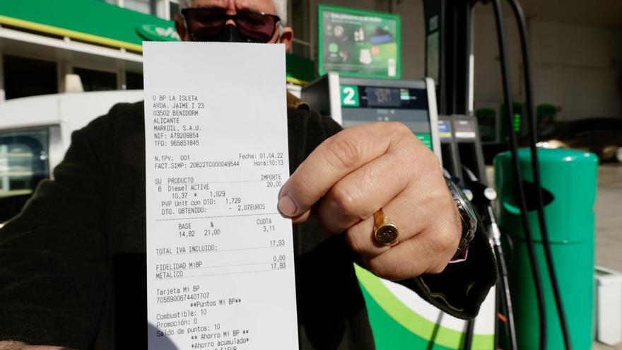 Un cliente muestra el ticket con el descuento en el carburante.