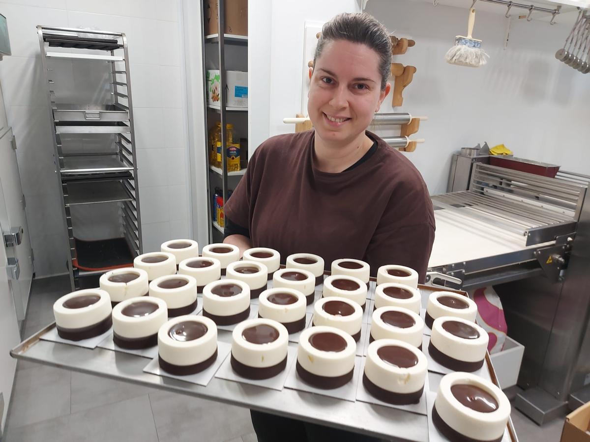 Andrea C. Bravo muestra una bandeja de pasteles recién hechos.