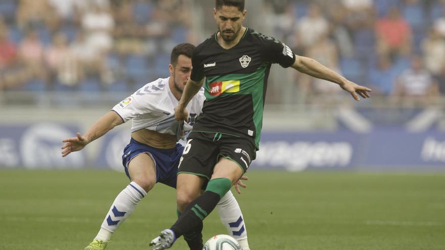 Fidel protege un balón ante un jugador del Tenerife.