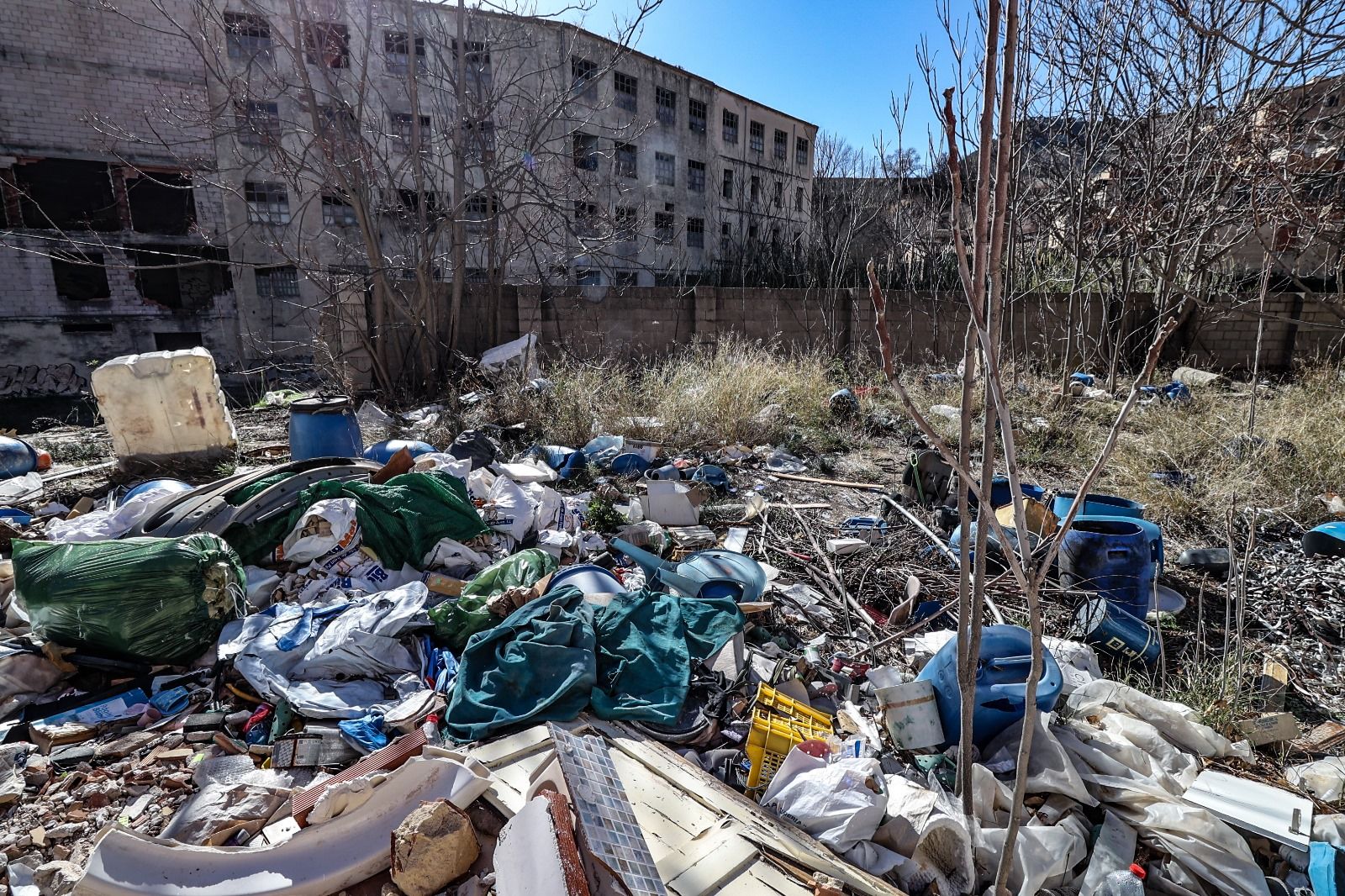 Escombros y basura acumulados junto al río Serpis y las fábricas de la calle Escalò de Alcoy