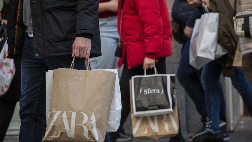 Varias personas con bolsas de la compra