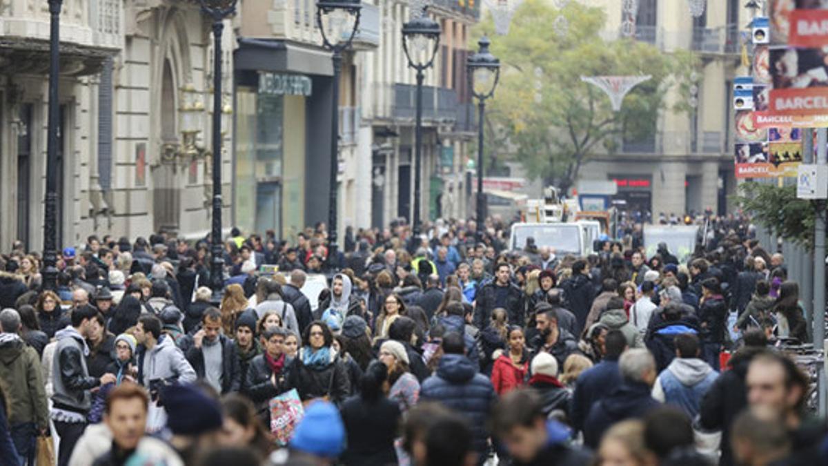 Una multitud de personas pasean en el Portal de l'Àngel de Barcelona.