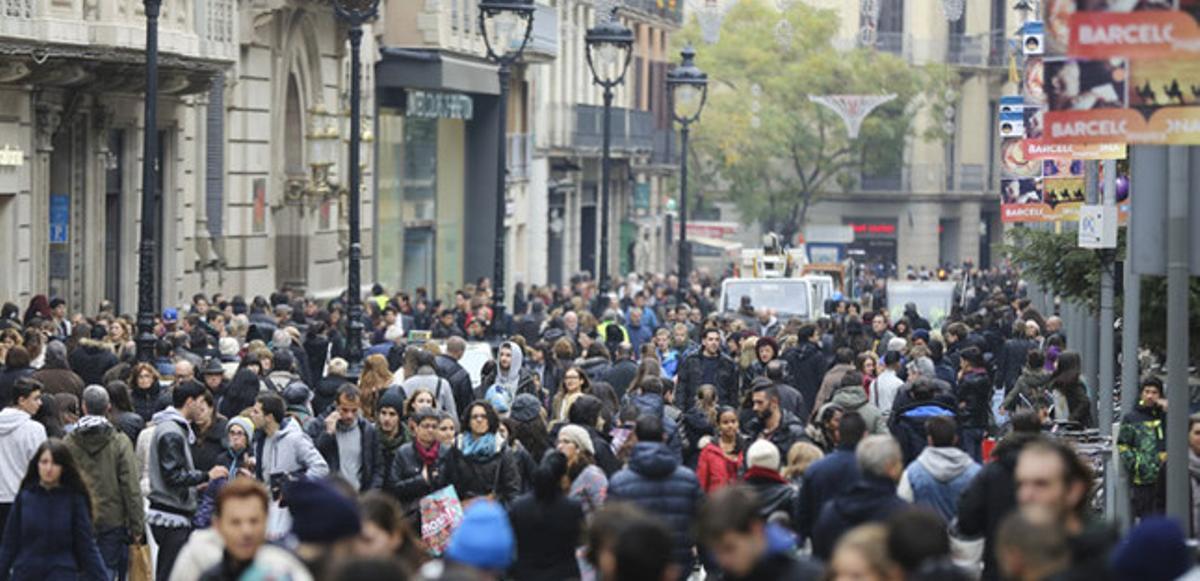 Una multitud de persones passegen al Portal de l’Àngel de Barcelona.