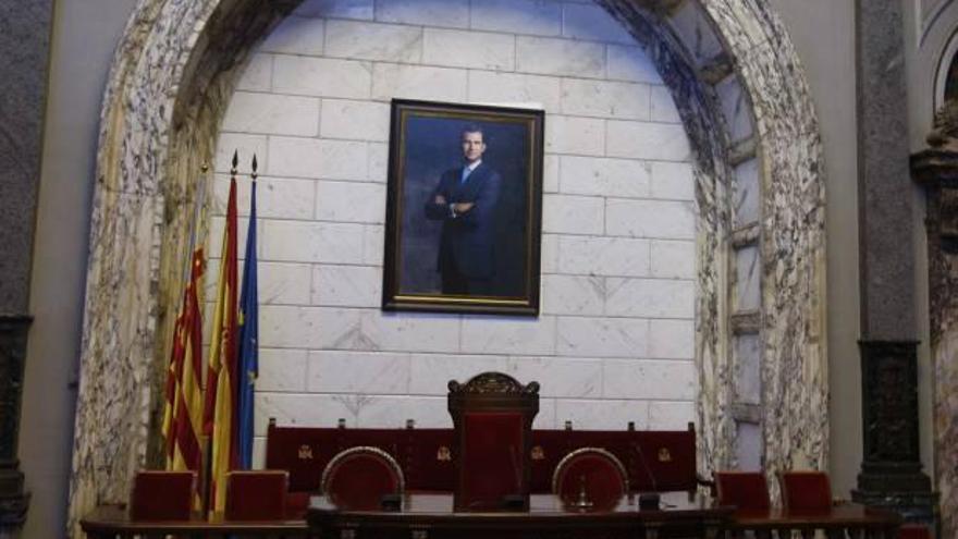 cambio de «atrezzo». El nuevo cuadro del rey Felipe VI colocado ayer en el salón de plenos del Ayuntamiento de Valencia y, a la derecha, momento en el que los operarios realizaron el cambio nada más ser proclamado soberano en las Cortes.