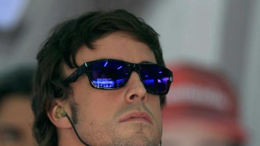 Alonso comprueba los tiempos en un monitor en el garaje de Ferrari. | reuters