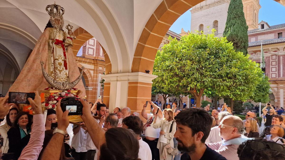 La presidante de la UCAM, María Dolores García, portó a hombros la imagen de la patrona durante el recorrido por el claustro de los Jerónimos