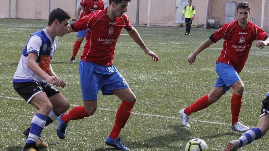 Un jugador del Domaio trata de recuperar un balón ante la presión de un jugador rival. // Santos Álvarez