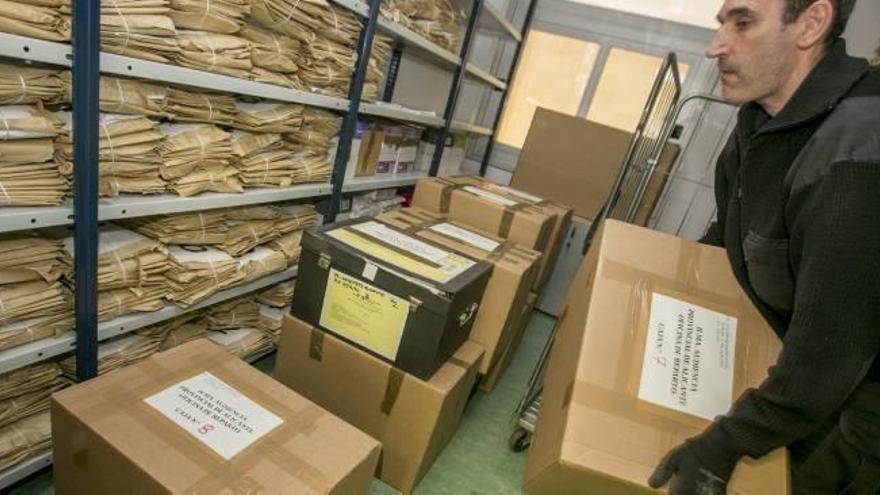 Los operarios depositan las cajas con la causa en el archivo de una sección de la Audiencia.