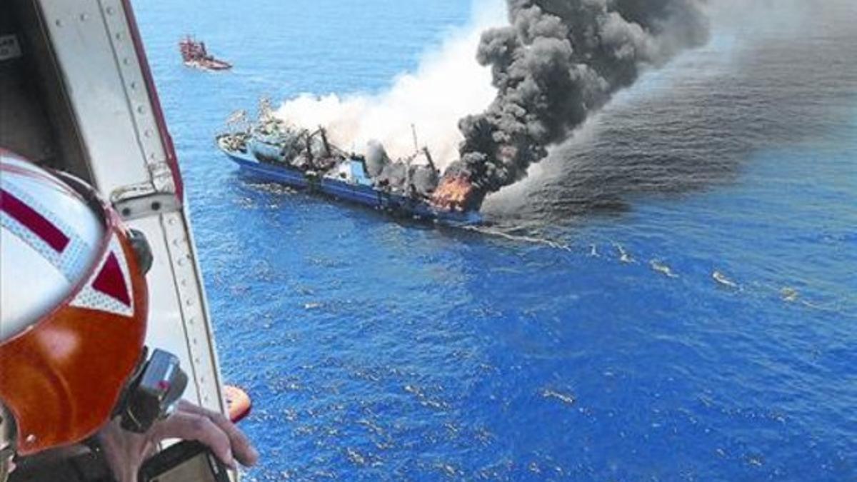 El pesquero incendiado antes de hundirse, en una foto tomada desde un helicóptero de Salvamento Marítimo.