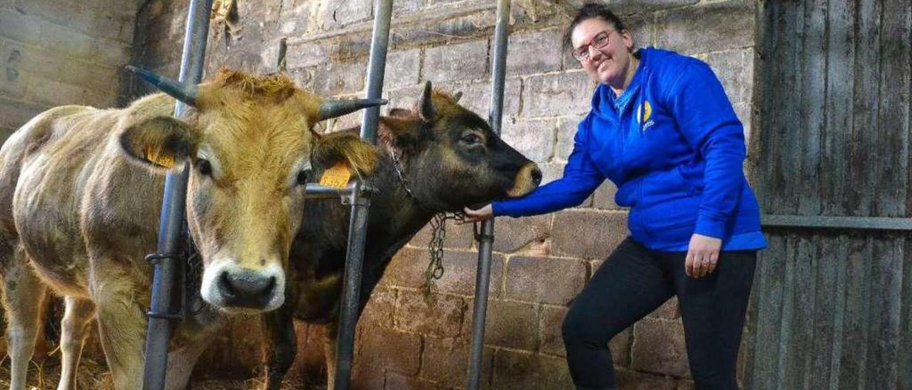 Patricia Martínez García, con una xata y un xatu de la ganadería familiar, en Villavaler (Pravia).