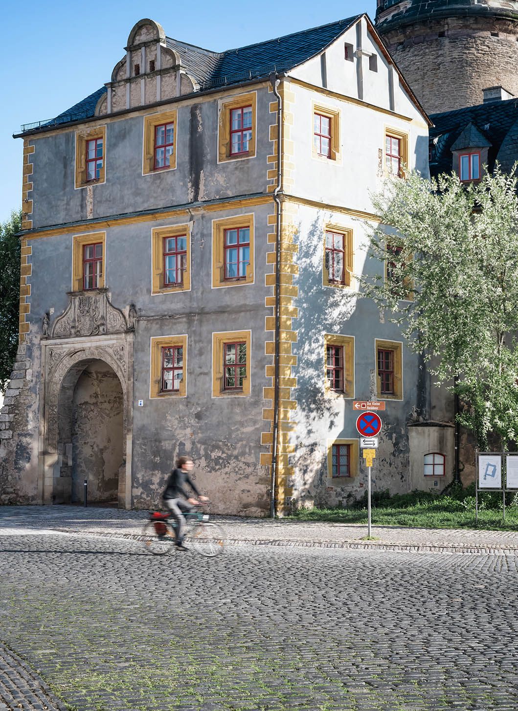 Ciclista pasa delante del acceso al palacio de Weimar.