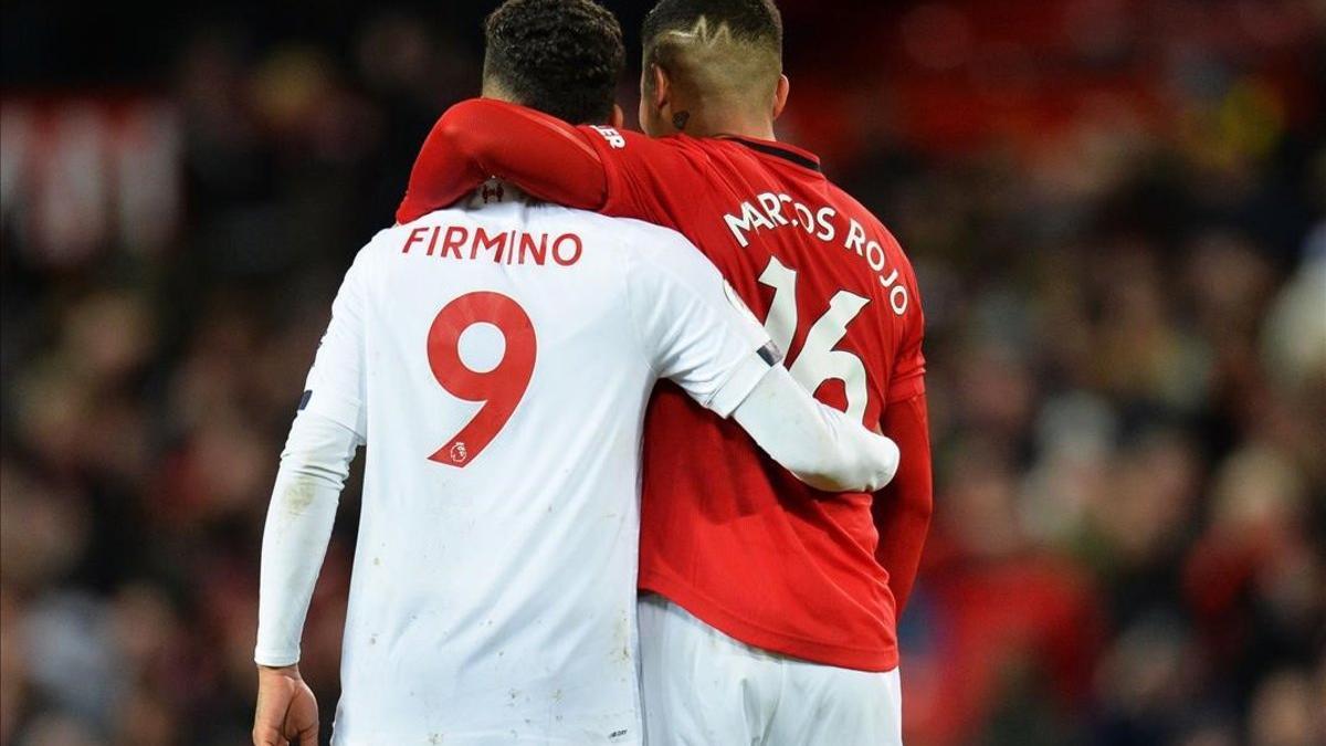 Roberto Firmino (Liverpool) y Marcos Rojo (Manchester United) se felicitan al final del duelo de Old Trafford.