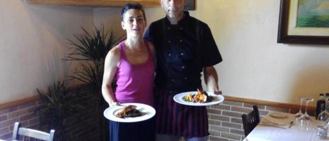 Lee y Ene, ayer en el salón del hostal con dos platos de su creación.