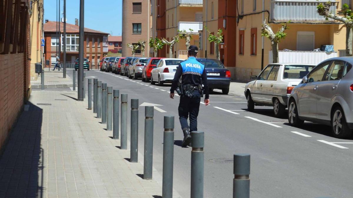 Un policía local camina por una calle de Benavente. | E. P.