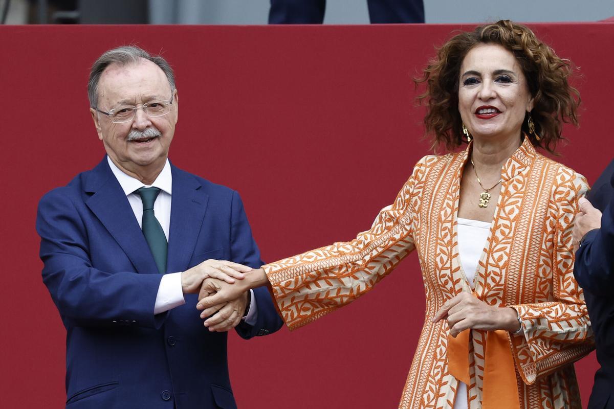 MADRID, 12/10/2025.- El alcalde-presidente de Ceuta, Juan Jesús Vivas (i), saluda a la vicepresidenta primera y ministra de Hacienda, María Jesús Montero, antes de presenciar el desfile de las Fuerzas Armadas con motivo de la Fiesta Nacional en la tribuna de autoridades este domingo. EFE/ Chema Moya