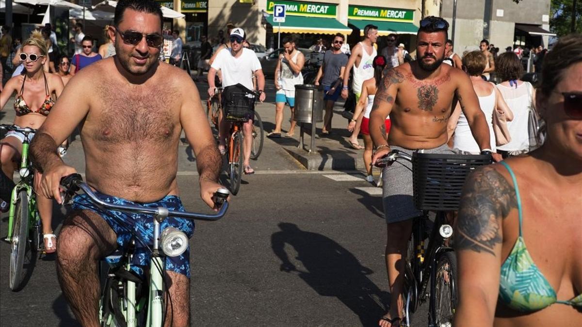 Un grupo de turistas pedaleando en bañador por la ciudad.