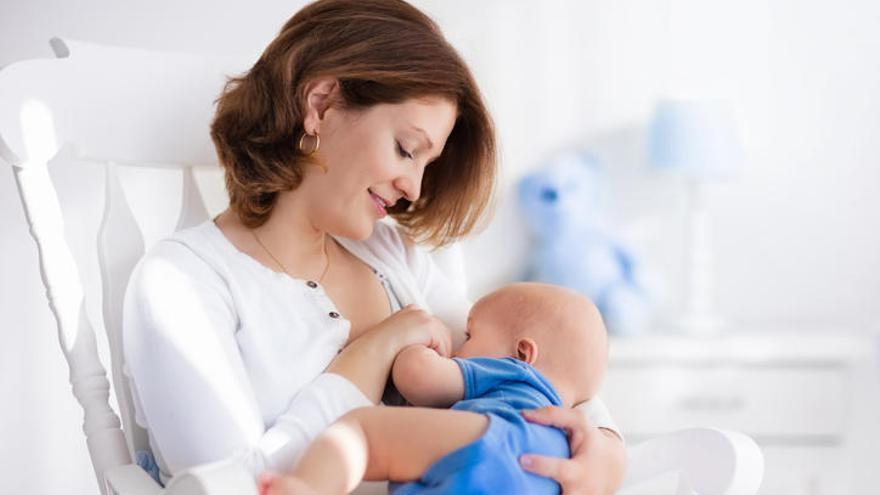 Una mujer amamantando a su hijo.