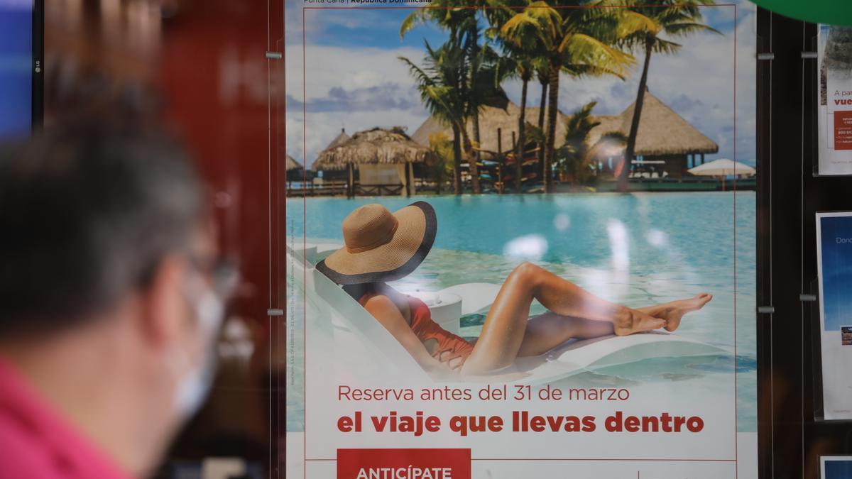 Un hombre pasa frente al escaparate de una agencia de viajes.