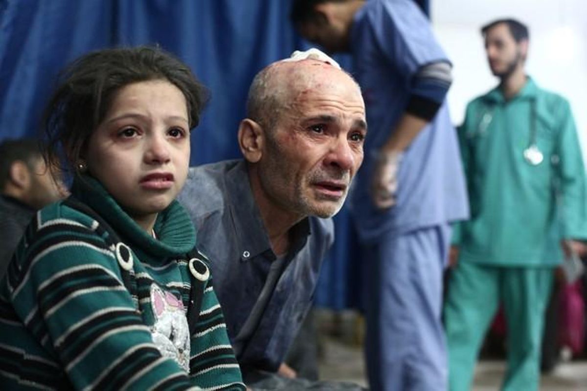 Un pare i la seva filla, ferits en el bombardeig del dia 11, esperen a ser atesos a l’improvisat hospital de Duma.