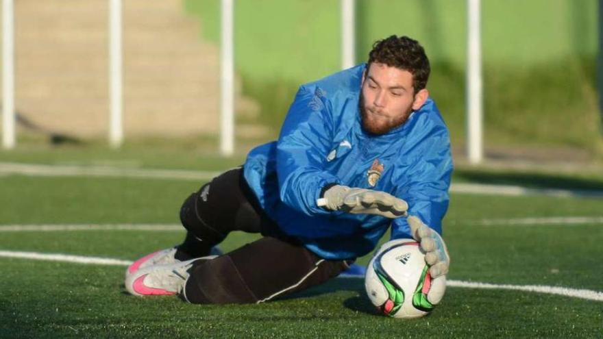 Vicente Company bloca un balón durante un entrenamiento. // Rafa Vázquez