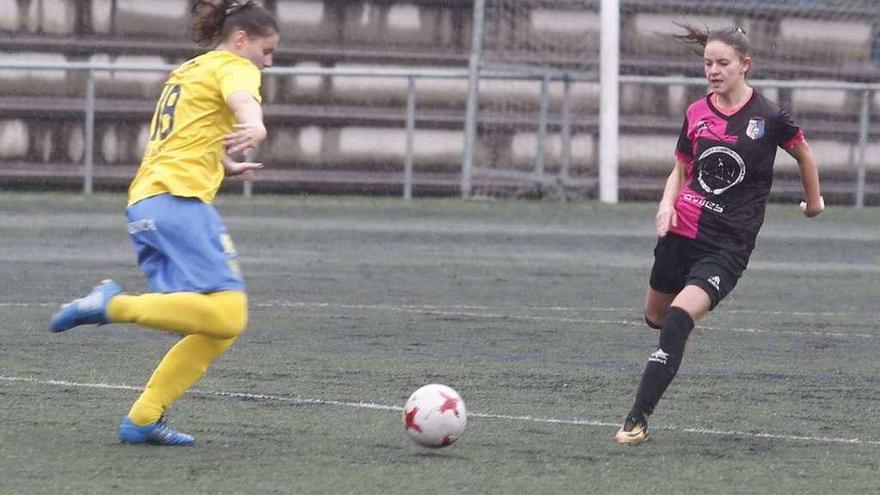 Carmen, del equipo rival, trata de golpear el balón ante la oposición de la jugadora local, Marina Monteserín.