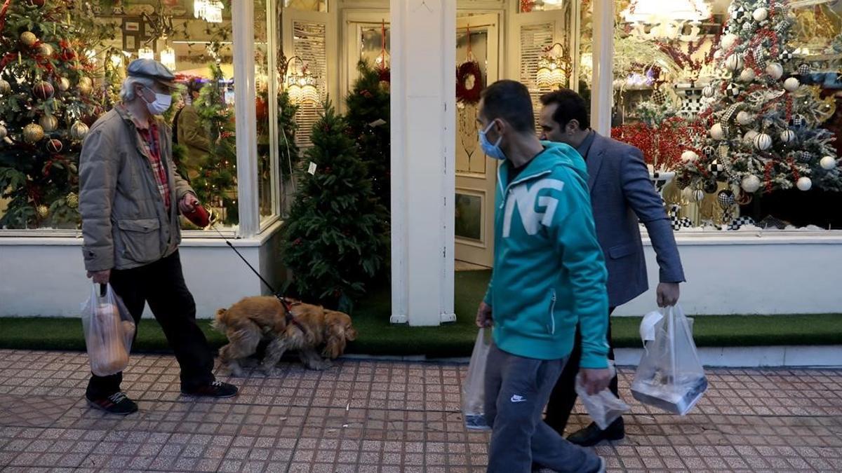 Peatones iranís pasan ante una tienda navideña en Teherán.