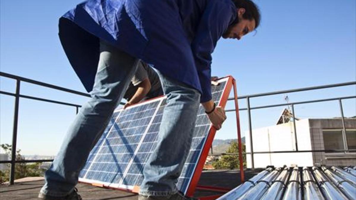 Un operario instala una placa solar técnica en Santa Coloma de Gramenet.