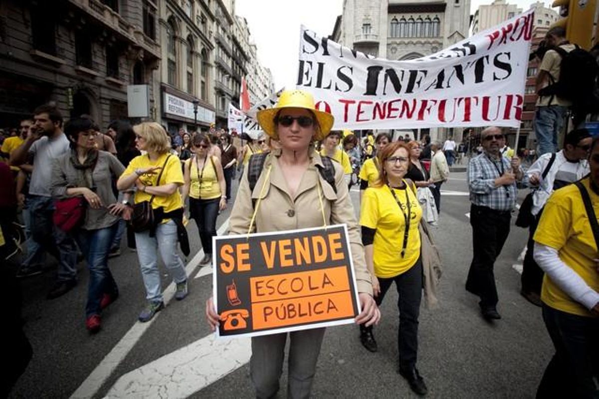 Una dona mostra un cartell reivindicatiu de ’Se vende’, durant la manifestació del 22-M contra les retallades en educació.