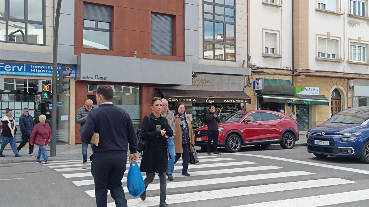 Peatones cruzan la calle Alcalde Parrondo por el paso regulado por el nuevo semáforo.