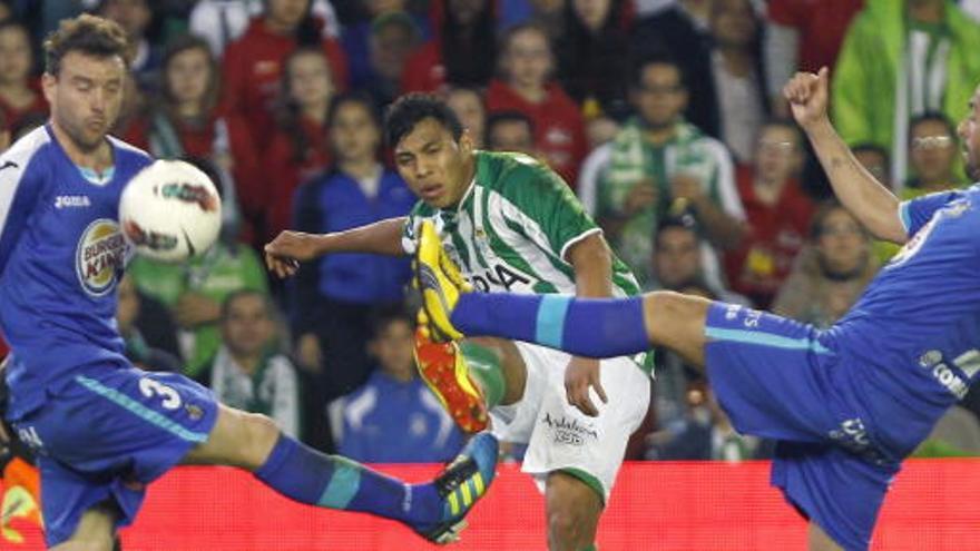 El centrocampista ecuatoriano del Real Betis Jefferson Montero (c) centra el balón entre los jugadores del Getafe CF José Manuel Jiménez &quot;Mané&quot; (i) y Diego Castro.