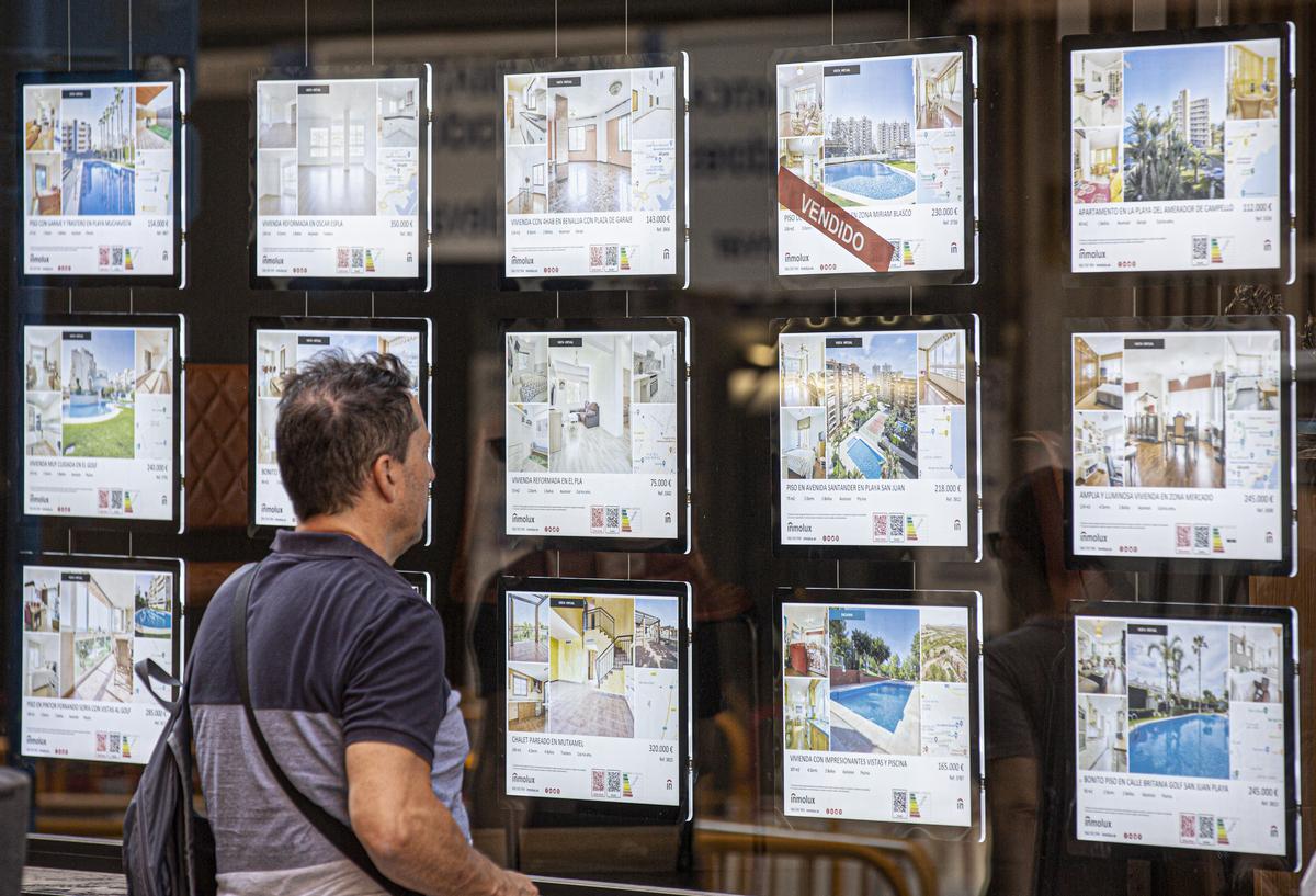 Un posible comprador consulta las ofertas de una agencia inmobiliaria en Alicante.