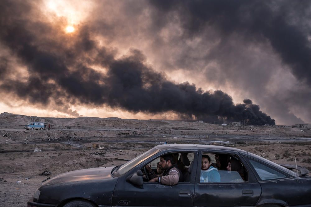 Pozos petrolíferos arden en las cercanías de Mosul, Iraq, mientras una familia huye de los combates que se destaan en la ciudad. Sergey Ponomarev.