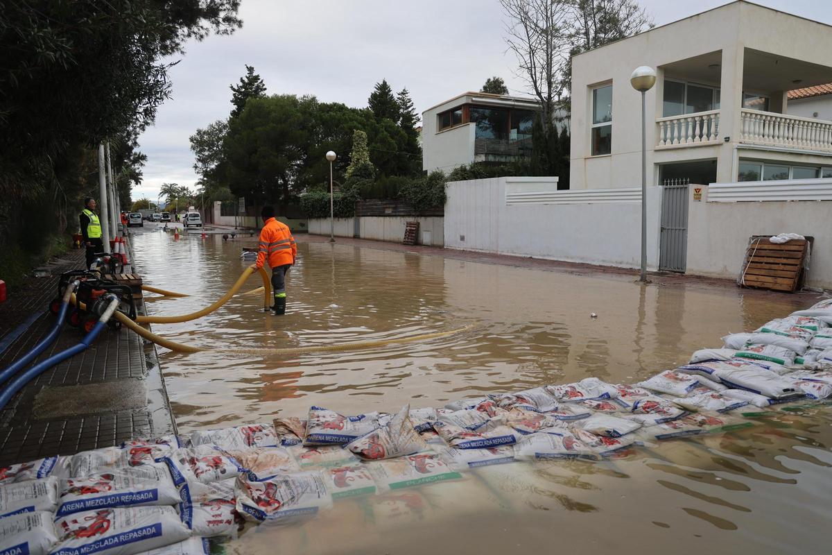 Trabajadores municipales, achicando agua en una calle de Malvarrosa de Corinto.