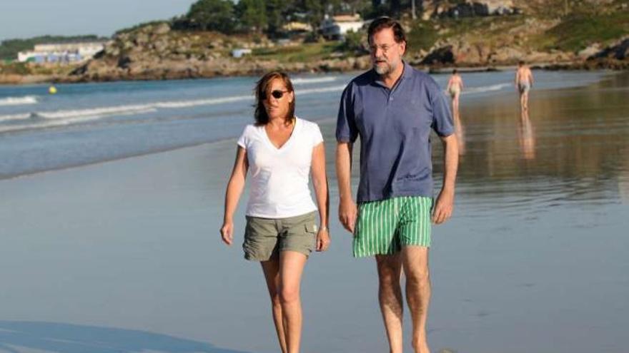 Rajoy y su esposa Elvira Fernández, paseando por la playa de A Lanzada (Sanxenxo). / rafa vázquez