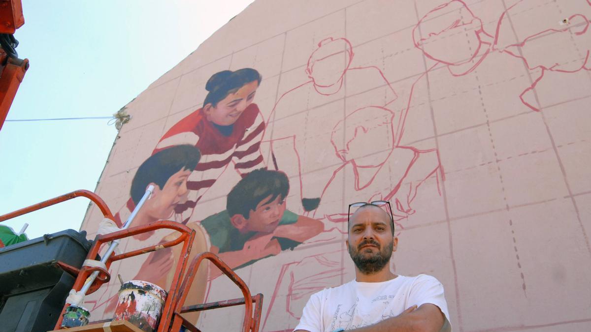 Yosepa MP junto al mural que está elaborando en A Bandeira con motivo de los 50 años de la Festa da Empanada.