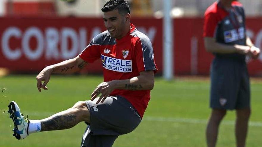 Reyes golpea el balón ayer en Sevilla, con Emery a la derecha.