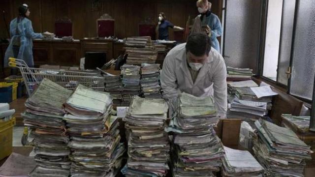 Los funcionarios, ayer, limpian los expedientes almacenados en la sala de vistas tras el incendio en la Audiencia.