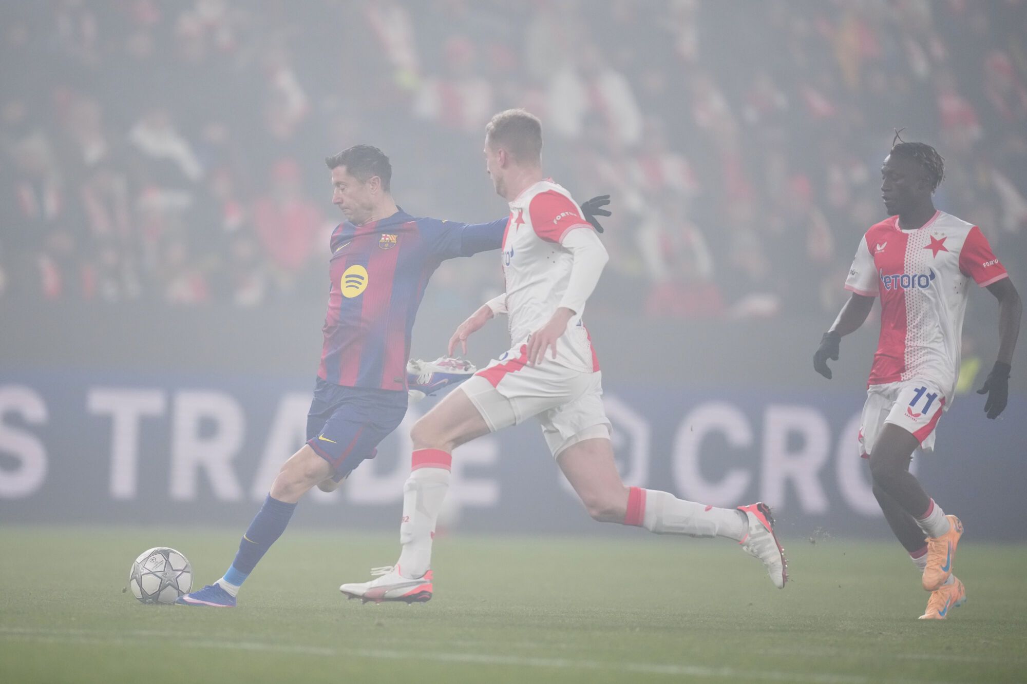 Barcelona's Robert Lewandowski, left, attempts a shot at goal in front of Slavia's David Zima during the Champions League opening phase soccer match between Slavia Prague and Barcelona in Prague, Czech Republic, Wednesday, Jan. 21, 2026. (AP Photo/Petr David Josek). EDITORIAL USE ONLY/ONLY ITALY AND SPAIN