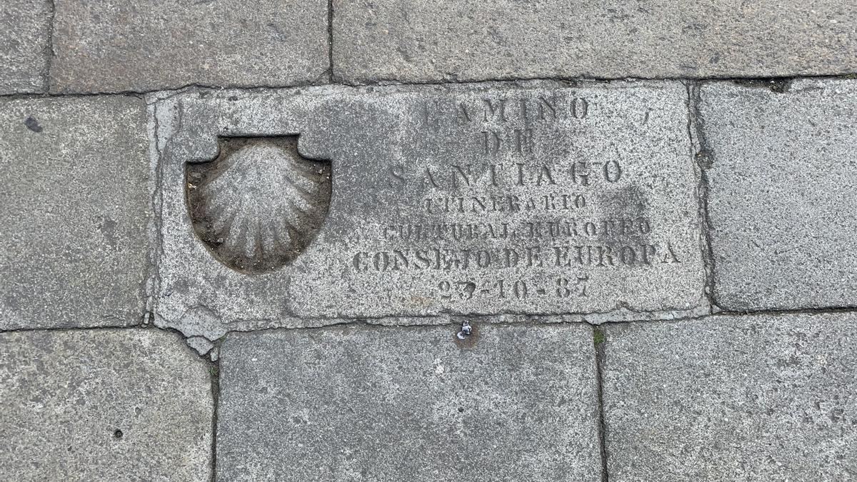 Casi ningún peregrino deja de hacerse una foto en la placa situada en la Plaza del Obradoiro