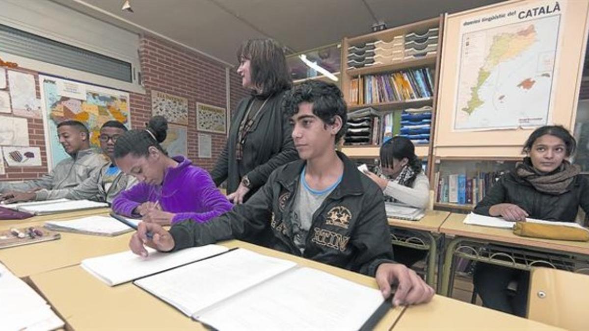 El servicio 8 La profesora Felicitat Fonollosa Pis y algunos de sus alumnos, en el aula de acogida del instituto de Roquetes.