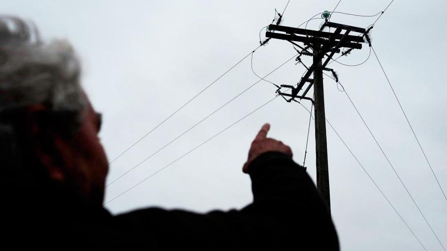 Una persona señala un tendido eléctrico el La Hiniesta, donde murieron varias aves electrocutadas.