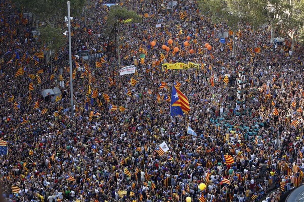 Mentre esperen que comenci la manifestació, centenars de milers de persones observen una torre de castellers al passeig de Gràcia amb Gran Via.