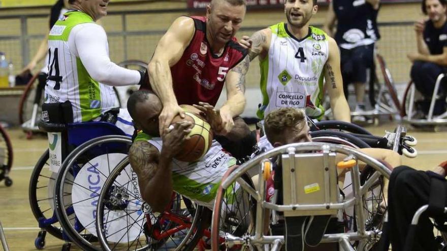 Dura pugna de Envó por la pelota durante un partido en el pabellón Pablo Beiro. // Adrián Irago