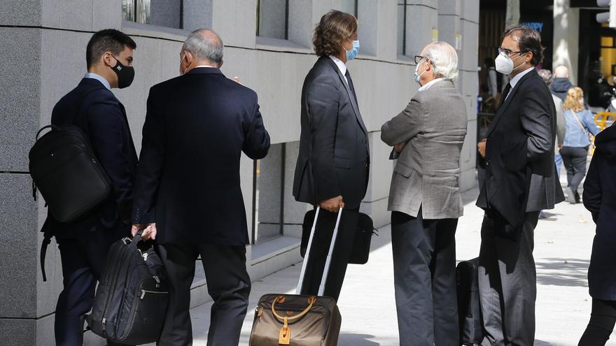 Roberto López, de espaldas, y Daniel Gil, de claro, con abogados del caso a la salida de la Audiencia.