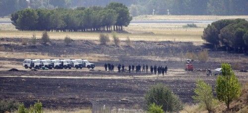 Spanish civil guards patrol the crash site of the Spanair jet crash at Barajas airport in Madrid