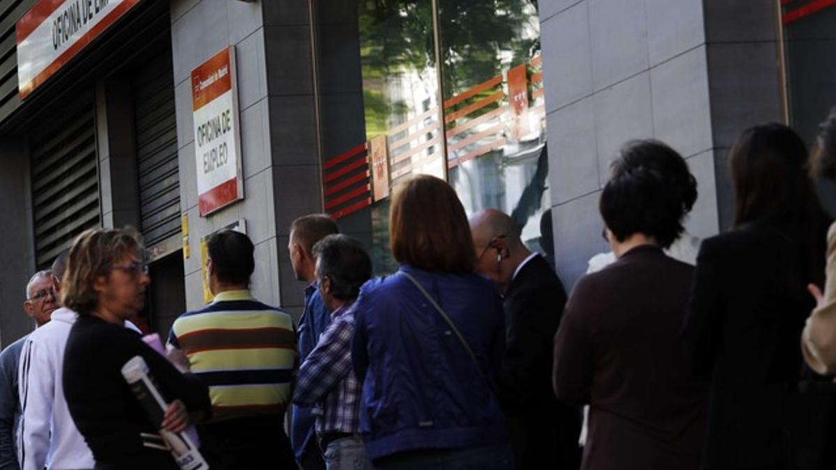 Un grupo de ciudadanos esperan ante una oficina de empleo en Madrid, el pasado mayo.