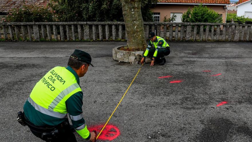 Dos agentes toman mediciones en el lugar del atropello múltiple de San Miguel de Deiro.