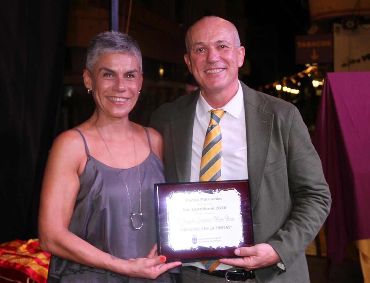 La alcaldesa, Mari Carmen Morales, entrega una placa al pregonero, Longinos Marín.