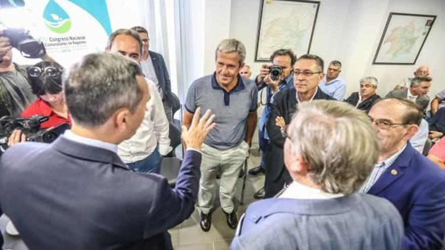 César Sánchez y José Antonio Andújar, ambos de espaldas, hablan con representantes de los regantes antes de iniciarse el acto.