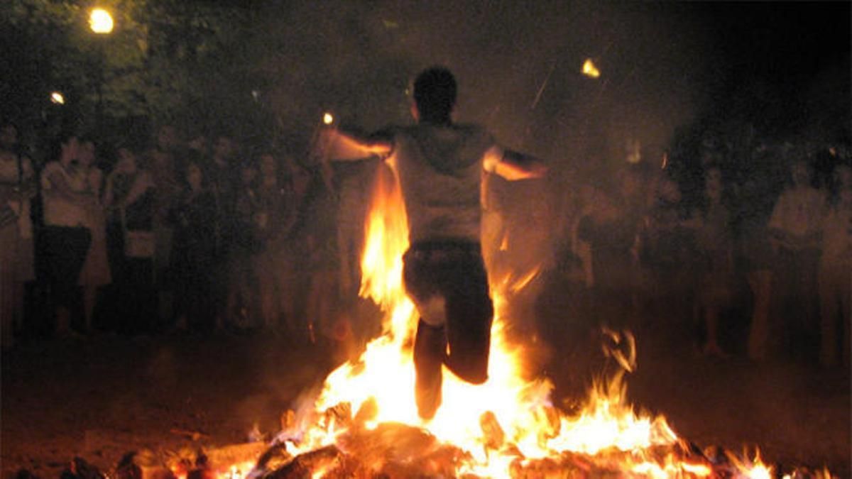 Un hombre salta una hoguera durante la noche de San Juan.